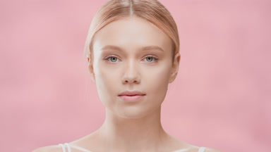 Blonde woman opens eyes moving head up and looking at the camera