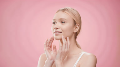 European woman touches face and turns head looking at the camera