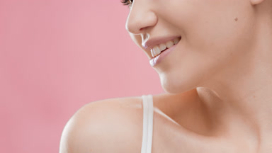 Fit attractive woman in white top smiles wide for the camera