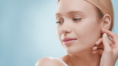 Attractive woman turns head touching jaw line and smiling wide