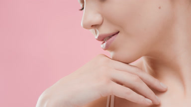 Fit woman touches clavicles and turns head looking at the camera
