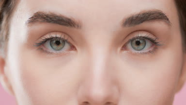 Female model with brown hair opens eyes looking at the camera