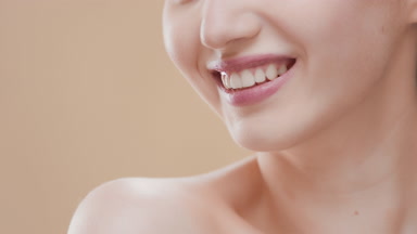 Female skincare model smiles wide for the camera moving shoulder
