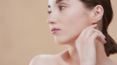 Beauty woman turns head to camera touching jawline with fingers