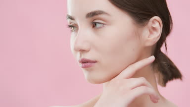 Skincare woman touches her jawline turning head to the camera