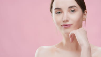Woman touches chin with hand turning body and looking at camera