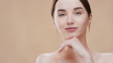 Girl touches chin with hand turning body and looking at camera