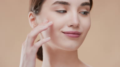 Attractive slim woman with brown hair turns head touching face
