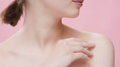 Female model with dark hair touches collar bones turning head