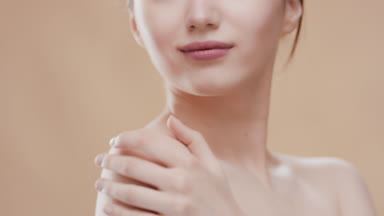 Cute woman touches her shoulder and looks at the camera smiling