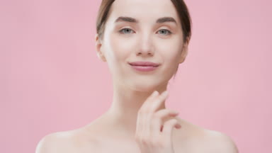 European woman touches her jawline smiling wide for the camera
