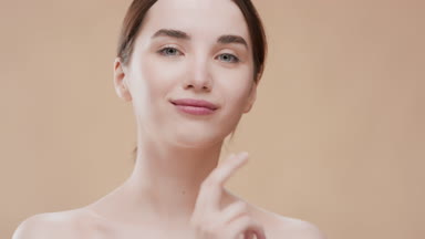 Caucasian girl touches her jawline smiling wide for the camera