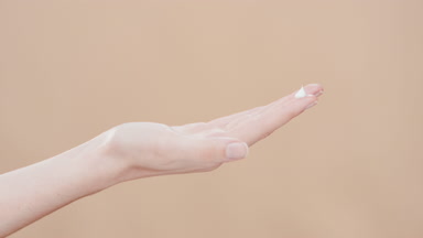 Female hand with a drop of moisturizer on forefinger