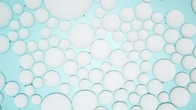 Big transparent bubble moves along grey smaller ones and bursts