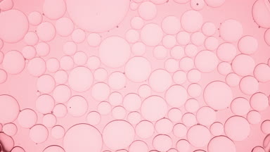 Big clear bubble moves along pale pink smaller ones and explodes
