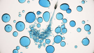 Blue liquid is injected into clear one with blue bubbles