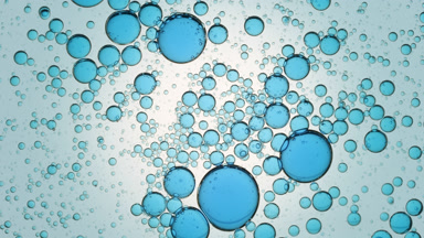 Blue different sized molecules move spontaneously in clear fluid