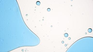 Big blue bubble moves to the left in fluid with smaller ones