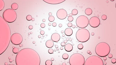 Pink different sized clear bubbles move slowly and spontaneously