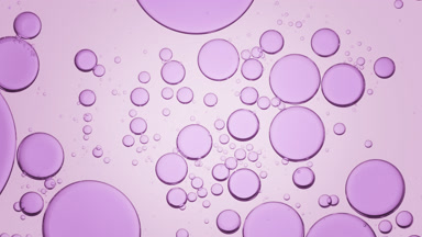 Purple bubbles move slowly and spontaneously in clear liquid