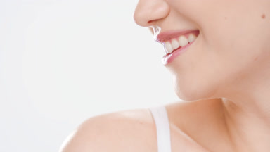 Female model in white crop top smiles wide looking to the right