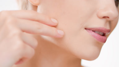 Fit European woman touches jaw line looking down and smiles wide