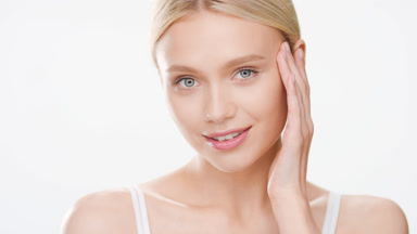 European young fit cute blond woman touches face smiling wide