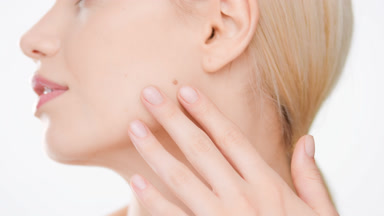 Slim woman with long light hair in ponytail ouches face and body