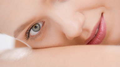 Female beauty model in white crop top puts head on hand lying
