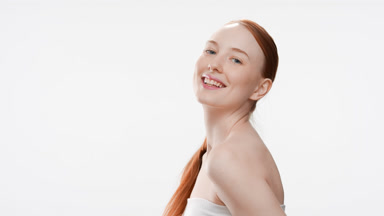 Young gorgeous fit Caucasian woman turns around smiling wide