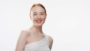 Attractive young woman in white top turns around smiling wide