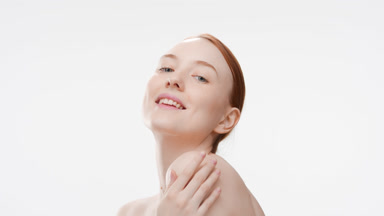 Good-looking fit Caucasian redhead girl touches shoulder smiling