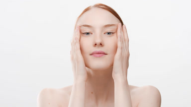 Gorgeous Caucasian woman smiles for the camera stretching skin