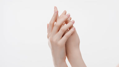Female body care model touches back of hand, wrist and forearm