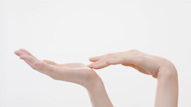 Female model touches fingers and palms and interlocks fingers