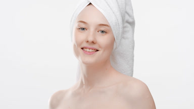 Caucasian fit woman touches clavicles turning body and smiling