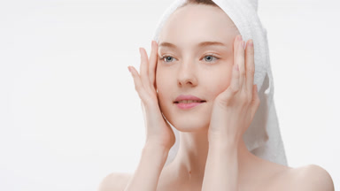 Slim woman massages temples stretching skin and touches cheeks