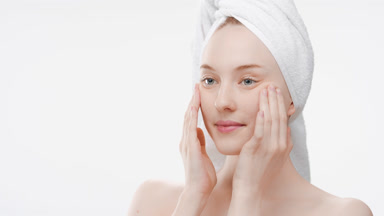 Fit woman touches face stretching skin and smiles for the camera