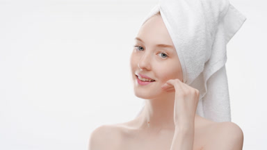 Cute woman touches chin and jawline turning body and smiling