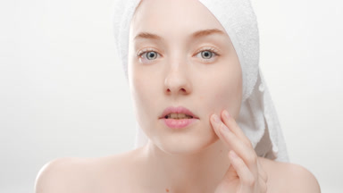 Attractive girl touches face, extracts blackheads and smiles