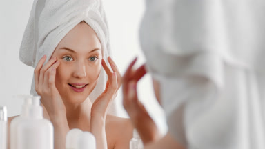 Attractive Caucasian woman touches face tapping and smiling wide