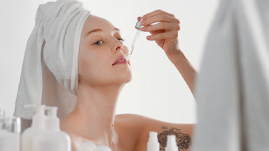 Good-looking woman puts skincare serum on chin using a dropper