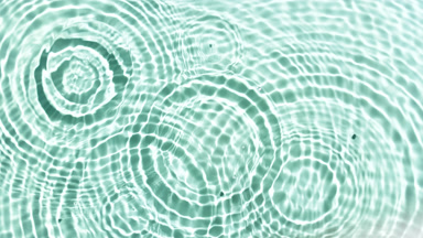 Drops falling in water with wave on green mint bg