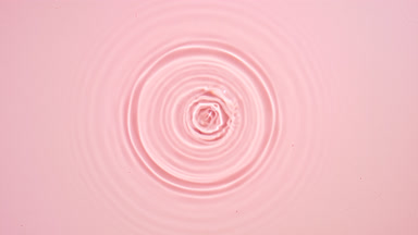 Drop falls down creating circles on water surface