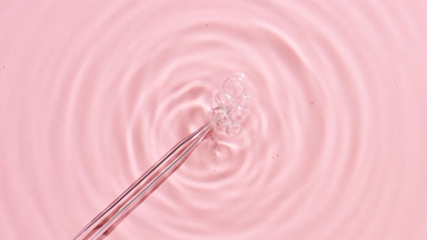 Air bubbles comes from chemical dropper on pink background