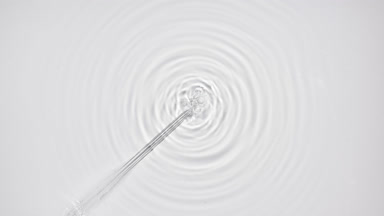 Liquid is injected from syringe creating bubbles and circles