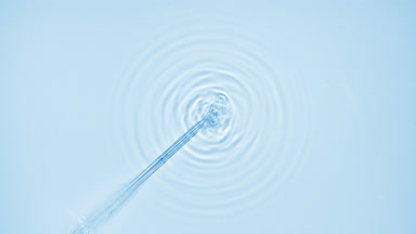 Air bubbles comes from chemical dropper on blue background