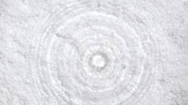 Clear drop falls down creating concentric circles on water