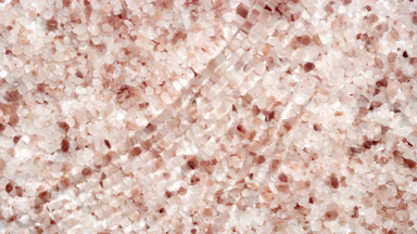 Water flows creating waves and ripples on pink salt background