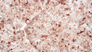 Wave making ripples on water surface over brown mineral crystals
